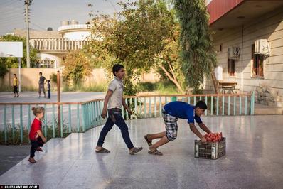 کودکان قاراقوش یک جعبه گوجه را که از یک کامیون محصولات کشاورزی که از کنار مدرسه سلامه می گذشت گرفته اند برای خانواده هایشان می برند. بیش از نیمی از 1.45 میلیون نفر عراقی آواره شده از ژانویه کودک هستند. 