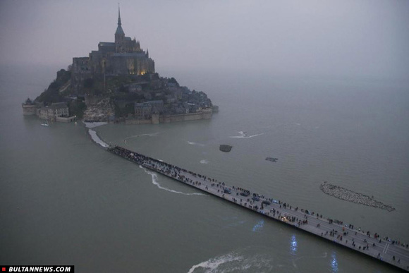 همانطور که در عکس هم پیداست بخشی از پل ارتباطی این جزیره با فرانسه بر اثر بالا آمدن آب دریا به زیر آب رفته و تعداد زیادی از مردم در حال عکاسی از این اتفاق نادر هستند