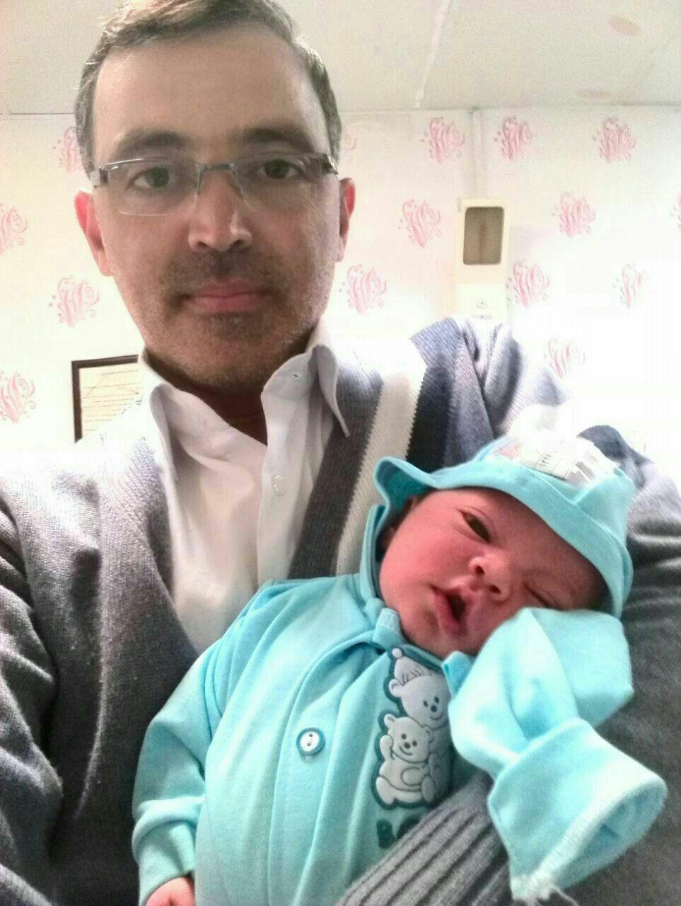 شهید جواد محمدی فعال فرهنگی مشهدی با فرزند چند روزه اش