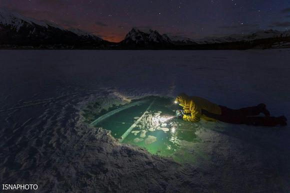 عكاسي از حفره اي در سطح یخ زده دریاچه آبراهام در آلبرتا کانادا